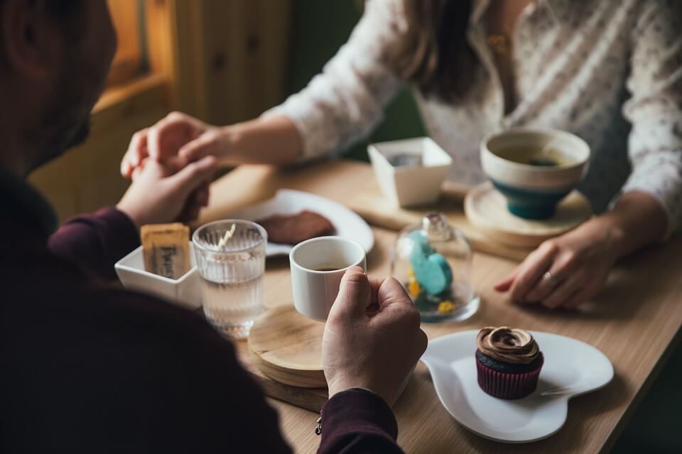 A couple in love holding hands at a table in a coffee shop