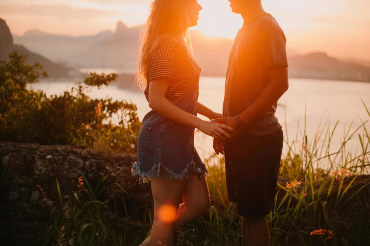 Flirtmydream - lovers stand holding hands against the backdrop of sunset