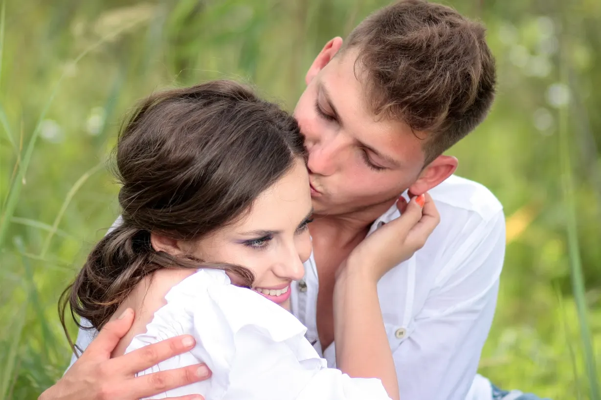 LuxuryDate - young couple in love hugging in the meadow